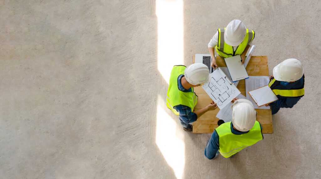 Team of engineers looking over blueprints to building